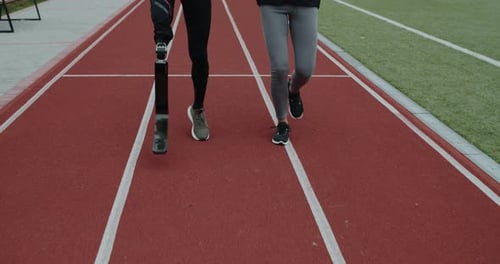Crop View of Disabled Man with Amputated Leg and Sports Woman Jogging
