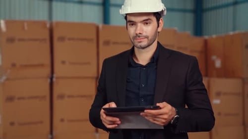 Factory Manager Using Tablet Computer in Warehouse or Factory