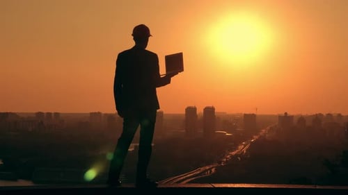 Engineer Silhouette with Laptop at Golden Sunrise