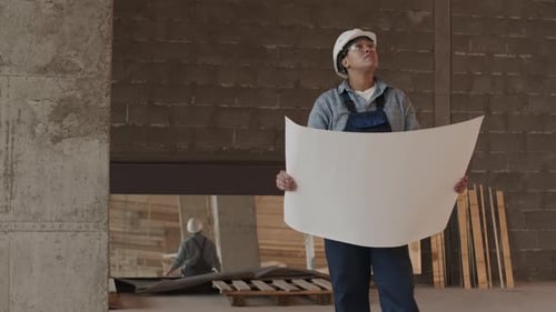 Construction Worker Reviewing Blueprints on Site