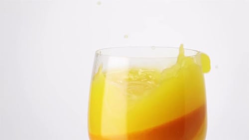 Orange Wedge Plunges Into Glass of Juice