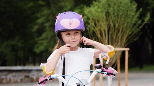 Girl Putting On Helmet Before Riding Bike Girl Putting On Helmet Before Riding Bike