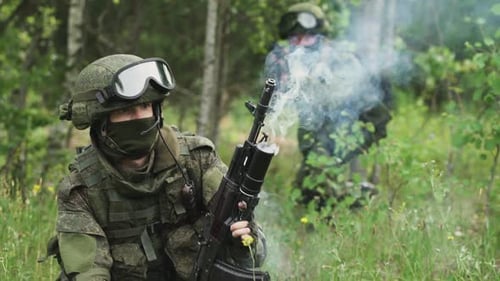 Soldat in Tarnung feuert einen Granatwerfer im Sturmgewehr ab Militärische Aktion in Waldsoldaten