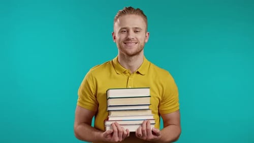 European Student in Yellow Wear Holds Stack of University Books From Library on Blue Background in