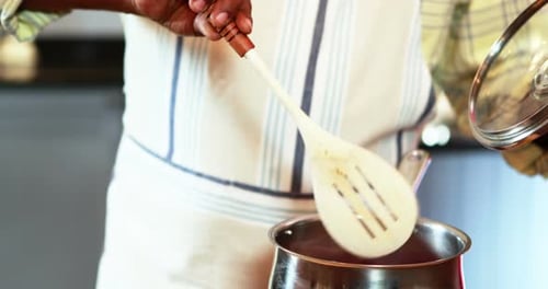 Adult Cooking with Wooden Spoon in Kitchen
