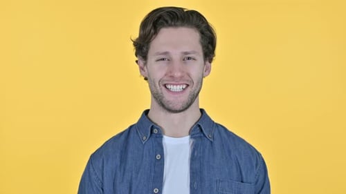 Young Man Smiling at the Camera on Yellow Background