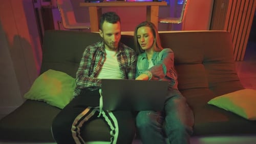 Couple Using Laptop Computer Together on Couch