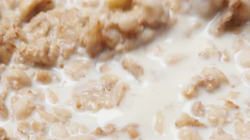 Spoon Stirring Cereal and Milk in Bowl