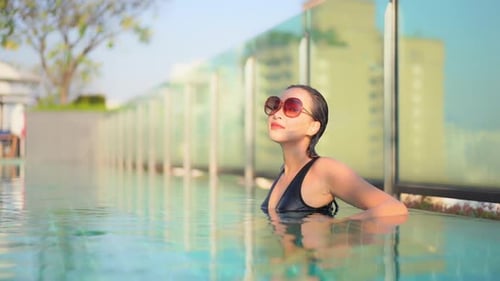Young asian woman enjoy around outdoor swimming pool for leisure