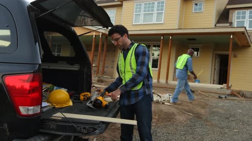 Construction worker cutting siding