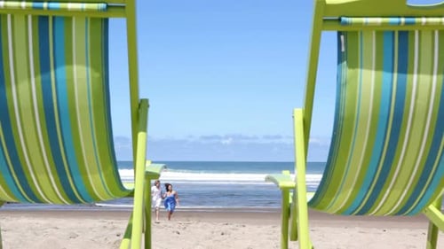 Couple running on beach to chairs