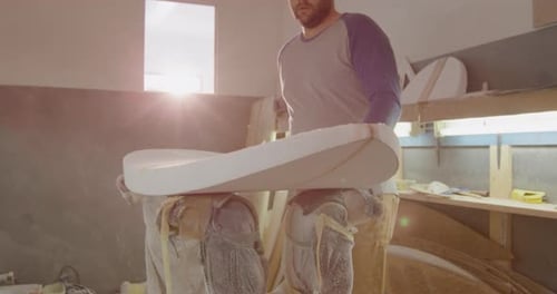 Male surfboard maker in his workshop