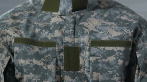 Soldier Holds Up Army Sign in Camouflage Uniform