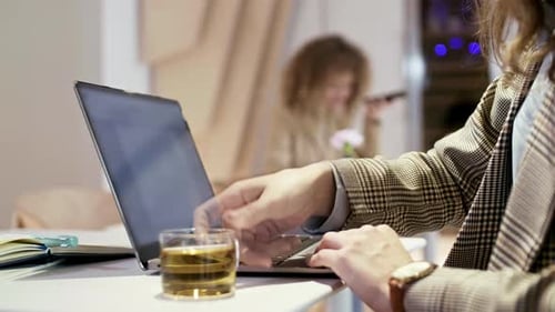 Femme d'affaires travaillant sur PC tout en buvant du thé