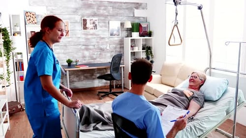 Team of Young Doctor Talking with Old Woman