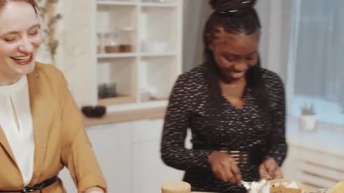 Women Preparing Food and Laughing Together in Kitchen