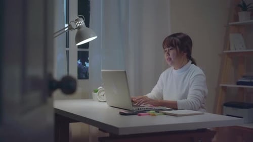 Woman Celebrates Working on Laptop at Night