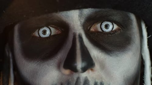 Close-up Shot of Face in Skeleton Halloween Makeup Opening Eyes with White Pupil, Trying To Scare