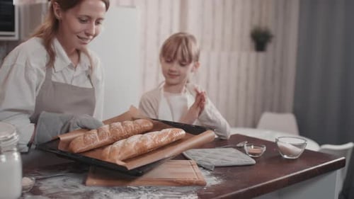 Woman and Child Baking Bread Together in Kitchen