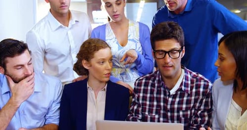Team Collaborating on Laptop in Modern Office Setting