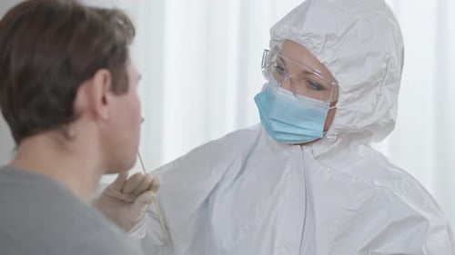 Closeup of Professional Caucasian Female Nurse Taking Covid19 Test Using Cotton Swab