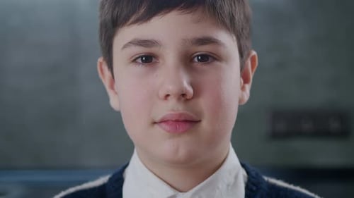 Closeup Portrait of 1213 Years Old Boy Looking at Camera at Home
