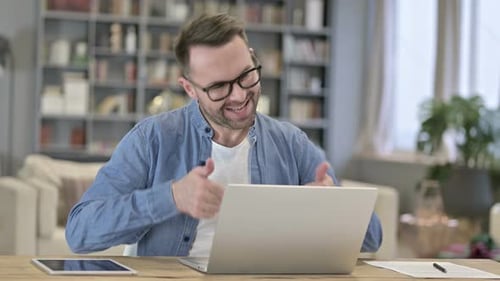 Man Video Conferencing on Laptop Computer at Home