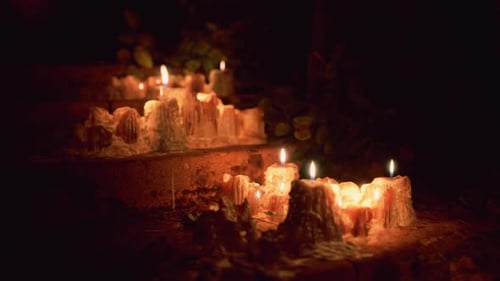 Burning Candles with Melted Wax on a Dark Background