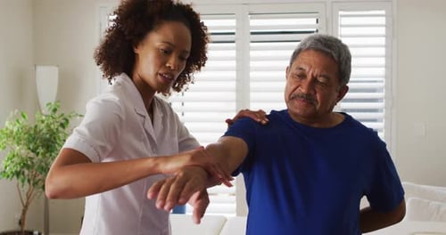 Woman Helping Senior Man with Arm Exercises