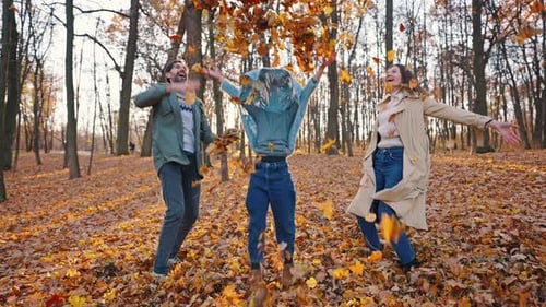 Family Throws Autumn Leaves in the Air