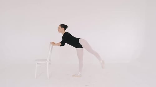 Ballerina in Black Performing with Chaior in White Studio Isolated