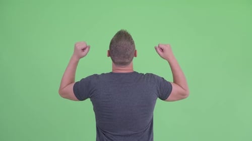Rear View of Happy Young Man with Fists Raised
