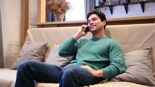 Young Adult Man Talking on Phone Relaxing at Home