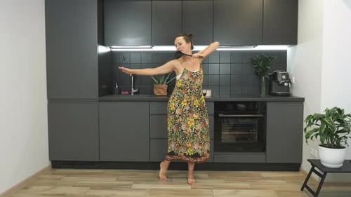 Woman Dancing and Singing in Modern Kitchen