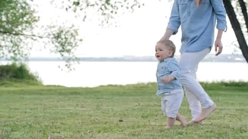 Adorable Toddler and Mother Running in Park