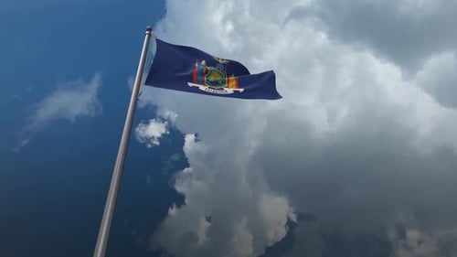 Waving New York State Flag Against Cloudy Blue Sky