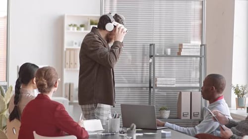 Man Uses VR Headset During Office Meeting