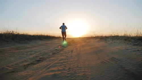 Person Runs on Desert Path at Sunrise