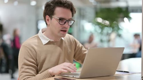 Man with Laptop Celebrating in Office