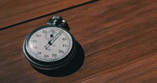 Stopwatch Ticking on Wooden Table
