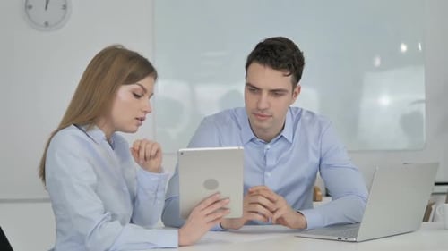 Young Adults Collaborating Using a Tablet in Office