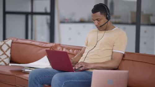 Man Works Remotely at Home on Laptop