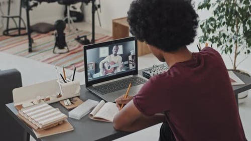 Student Taking an Online Guitar Lesson at Home