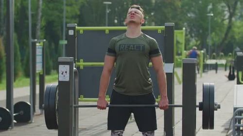 Hombre levantando pesas en un gimnasio al aire libre