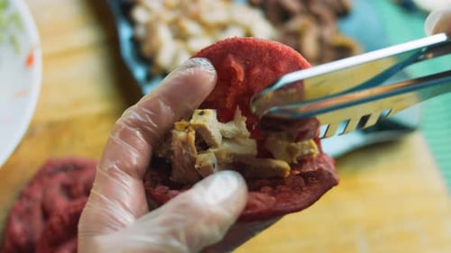 Close Up of Chicken Being Added to Flatbread