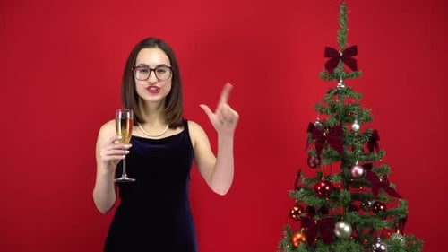Festive Woman Celebrates Near Christmas Tree with Champagne