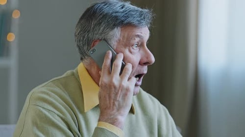 Man with Gray Hair Talking on Smartphone