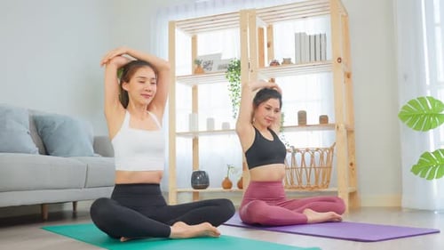 Two Women Exercising and Stretching Indoors