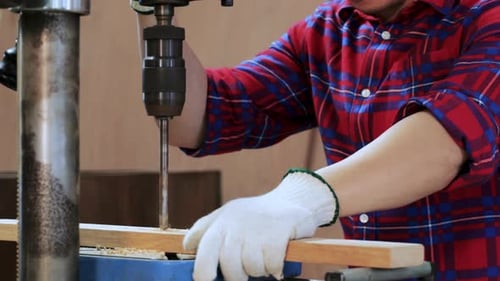 Close up of Carpenter Hand drilling wood by drilling machine in workshop