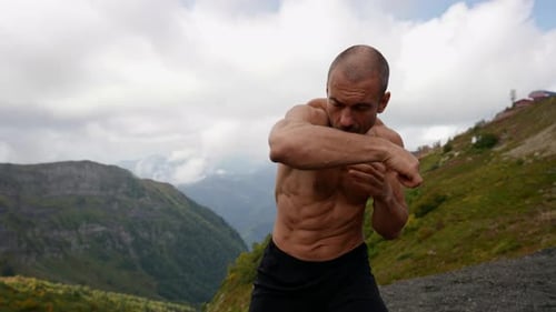 Shirtless Man Boxing in Mountain Landscape